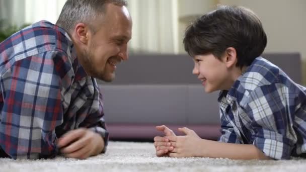 Família masculina brincando no chão em casa, se divertindo juntos, lazer de fim de semana — Vídeo de Stock