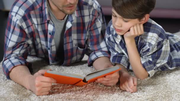 Hijo y padre pasando tiempo juntos leyendo un libro interesante, padres divorciados — Vídeo de stock