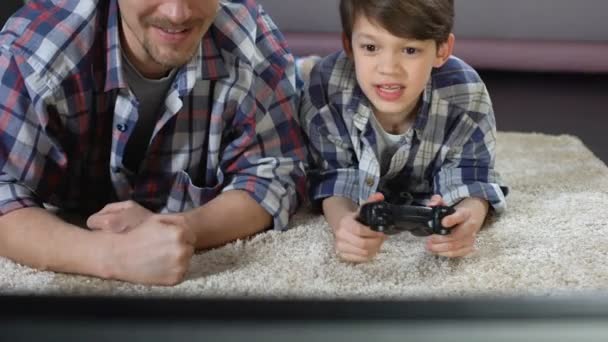 Mann unterstützt seinen kleinen Sohn beim Videospiel zu Hause, Familienbeziehung — Stockvideo