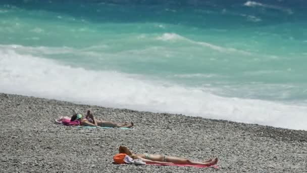Nice, Frankrijk - Circa juni 2016: Mensen op het strand. Zee golven op het strand van de zomer in Nice, ontspannen in de zon op vakantie, resort vakantie — Stockvideo