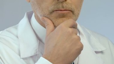 Problem çözme ve karar eliyle çenesini üzerinde doktor orta yaşlı