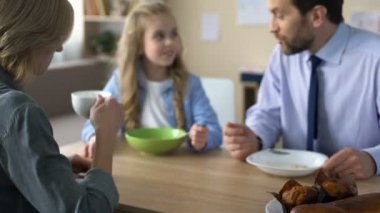 Mutfak masasında mutlu aile oturma ve Kahvaltı, sabah ritüeli