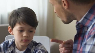 Baba oğlu kötü davranış için kızıyor, çocuk disiplin tartışır, sakin kalır