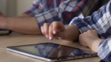 Tablet dizüstü bilgisayarda çalışan baba ise mobil oyun oynayan itaatkâr çocuk