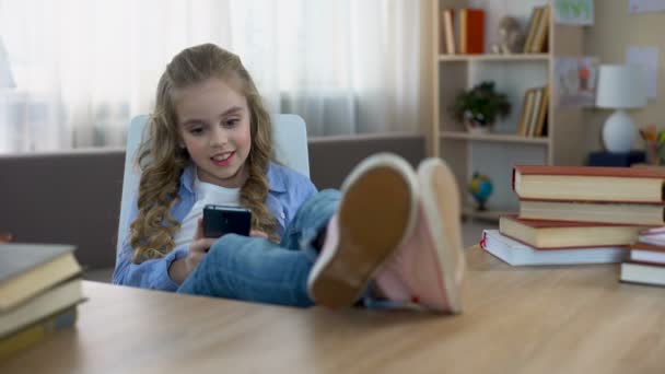 Niño Sonriente Sentado Mesa Jugando Teléfono Inteligente Adicción Gadget — Vídeos de Stock