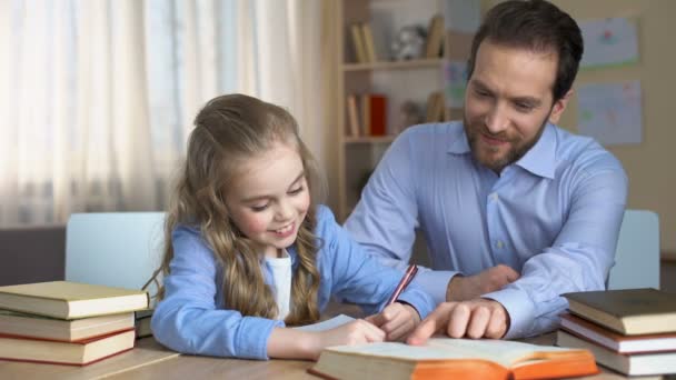 Glückliches Weibliches Kind Beim Hausaufgabenmachen Mit Ihrem Fürsorglichen Papa Unterstützung — Stockvideo