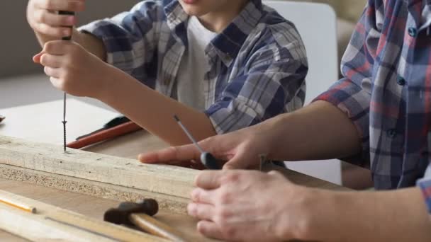 Padre enseñando a hijo a insertar tornillos, compartir la experiencia de trabajo de reparación, primer plano — Vídeos de Stock