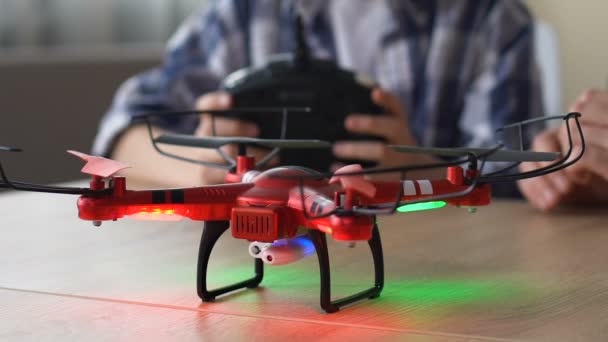 Chlapec s rozzářené oči působí drony, využívá dálkového ovládání, otec sedí poblíž — Stock video