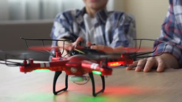 Niño operando dron con control remoto, riendo, padre sentado cerca, de cerca — Vídeos de Stock