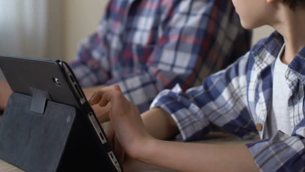 Boy using tablet, surfing internet, playing easy games while father working — Stock Video