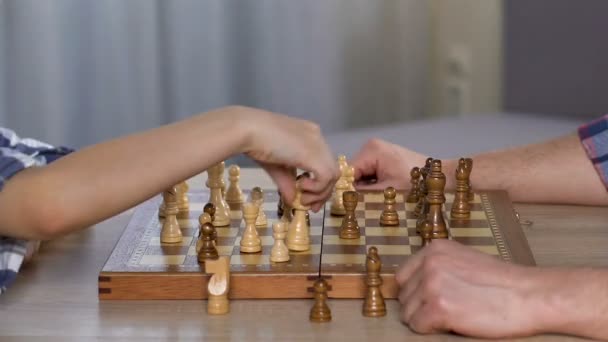 Сын играет в шахматы с отцом, дает пять, свободное время, счастливы вместе — стоковое видео