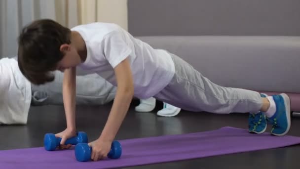 Padre enseñando a su hijo a hacer ejercicio push-up, estilo de vida saludable desde la infancia — Vídeo de stock