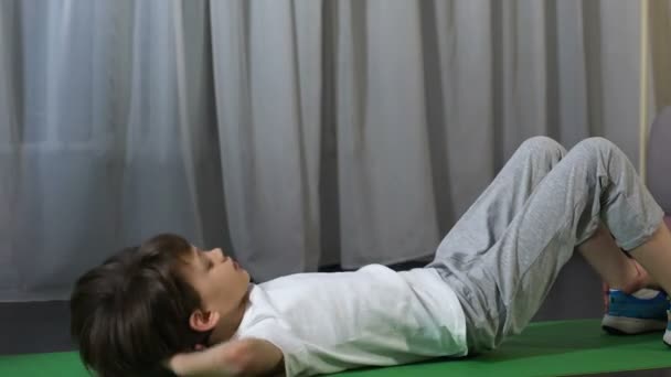 Niño haciendo abdominales, padre sosteniéndose los tobillos, actividad física — Vídeo de stock