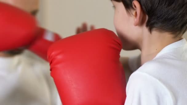 在体育学校, 自卫的男孩练习拳击拳与辅导员 — 图库视频影像