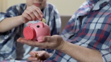 Oğul ve baba paralar kumbara ve mutlu bir şekilde sarılma, finansal okuryazarlık koyarak