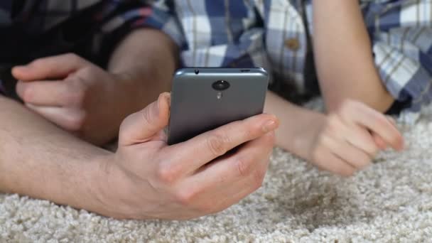 Vater zeigt Sohn Smartphone-Anwendung, spielt Spiel, surft im Internet — Stockvideo