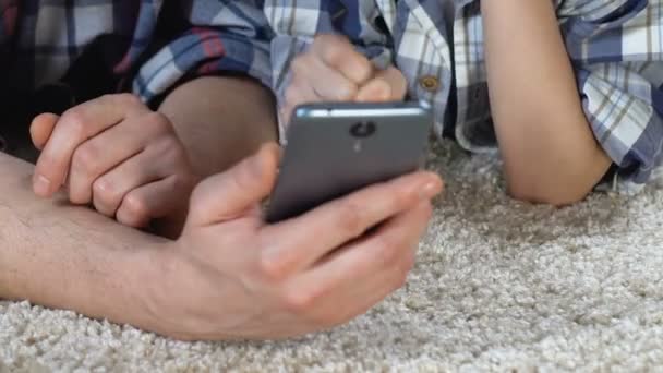 Niño de la escuela y el padre jugando juego en el teléfono inteligente en casa, divertirse, familia — Vídeo de stock