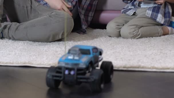 Мальчик играет с радиоуправляемой машиной домой, отец подарок на день рождения, дарит пять — стоковое видео