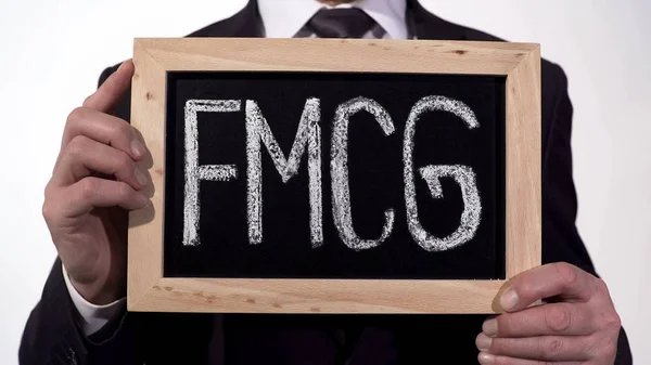 FMCG kirjoitettu liitutaululle liikemies käsissä, kulutustavarat, vähittäiskauppa — kuvapankkivalokuva