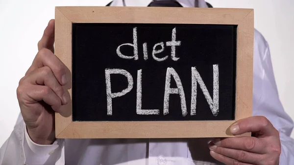 Kostholdsplan skrevet på tavle i ernæringsfysiologiske hender, vekttapstips, fedme – stockfoto