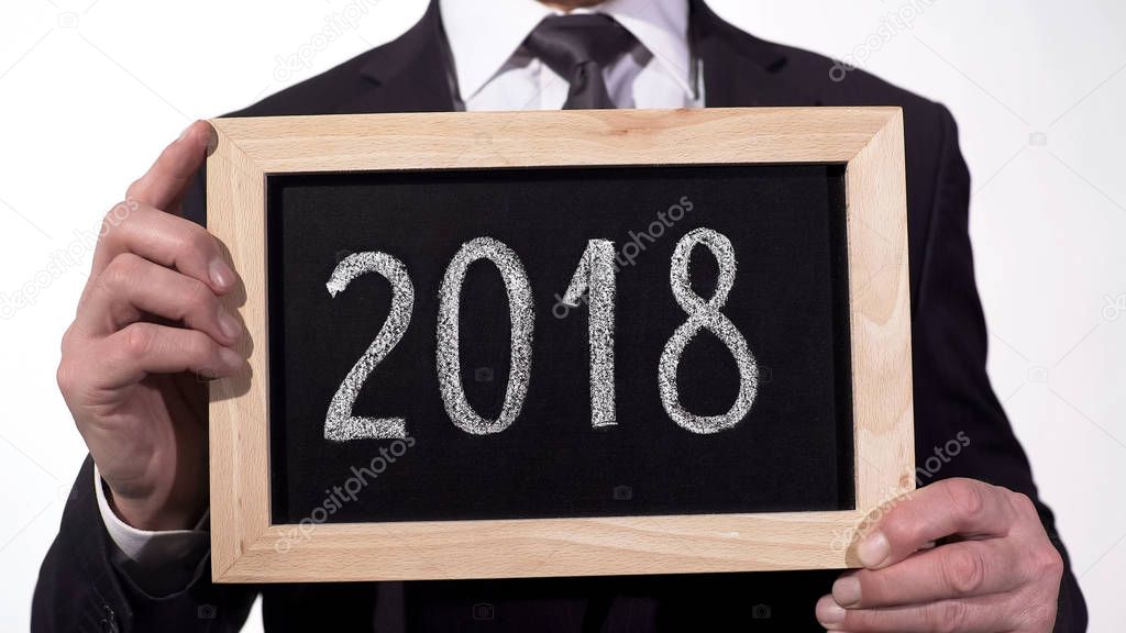 2018 written on blackboard in businessman hands, annual report, motivation