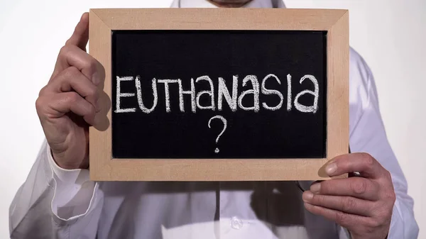 Otázka eutanazie na tabuli v rukou terapeuta, život nebo smrt rozhodnutí — Stock fotografie