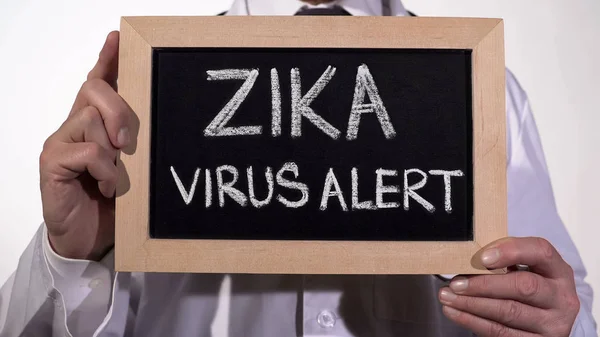Zika virus alert skrivit på tavlan i terapeut händer, infektionssjukdomar — Stockfoto