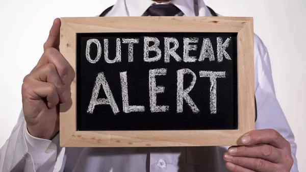 Utbrott varning text skriven på tavlan i läkare händer, epidemisk varning — Stockfoto