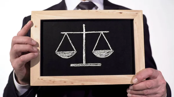 Justitie schalen getrokken op blackboard in handen van de advocaat, besluit voors en tegens — Stockfoto