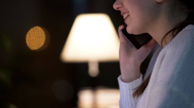 Smartphone üzerinde konuşmak ve gülümseyen, akşam Cafe, yakın çekim çekici genç kadın