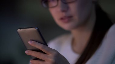 Mutlu genç kadın yeni uygulamada, baktılar smartphone sayfalarda tarama