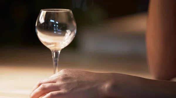 Mulher tocando vidro transparente de vinho em pé na mesa no café, close-up — Fotografia de Stock