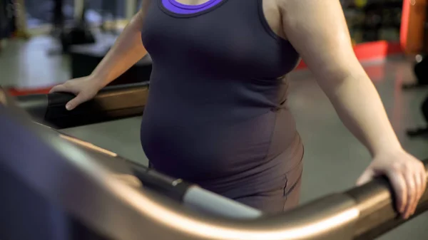 Young woman with excess weight actively exercising on treadmill for weightloss — Stock Photo, Image