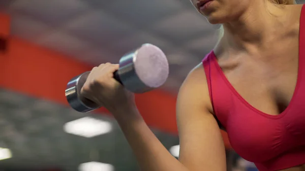 Strong sportive lady training arm muscles, exercising with dumbbells in gym — Stock Photo, Image