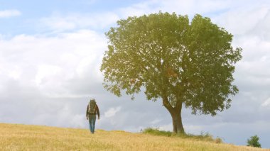 Erkek backpacker gidiş içine yüksek tepeler, aktif yaşam tarzı, eko-turizm tatil