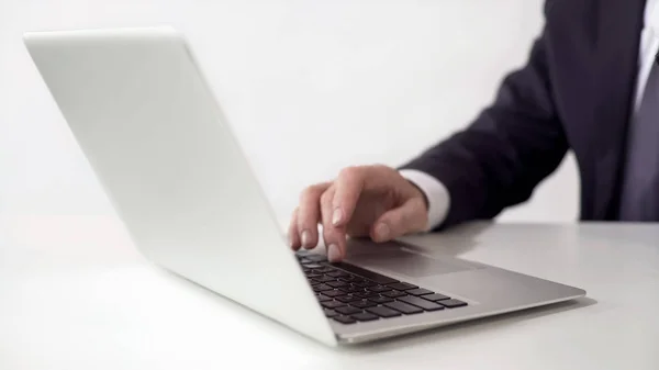 Uomo in tuta digitando sul computer portatile in ufficio, spingendo la barra spaziatrice, concetto di lavoro online — Foto Stock