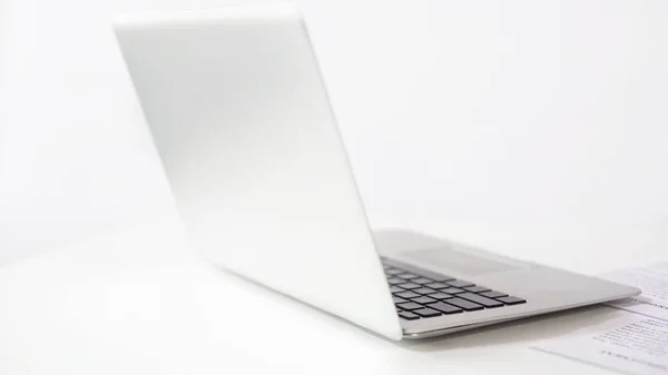 Laptop prata fina com contrato ao lado de fundo branco, conceito freelance — Fotografia de Stock