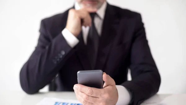 Ernstige beurs deskundige controleren nieuws op smartphone, analyseren van informatie — Stockfoto