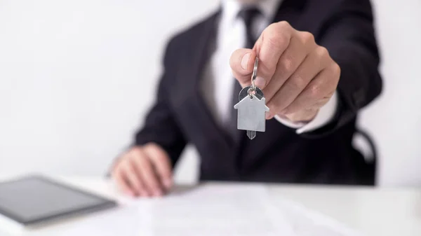 Corredor masculino sosteniendo casa llavero, firmando contrato, comprando una propiedad — Foto de Stock