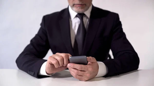 Empresário de meia idade usando smartphone, verificando notícias sobre bolsa de valores — Fotografia de Stock