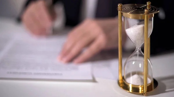 Крупним планом час вимірювання піщаних годинників, офіційний підпис важливого документа про реформу — стокове фото