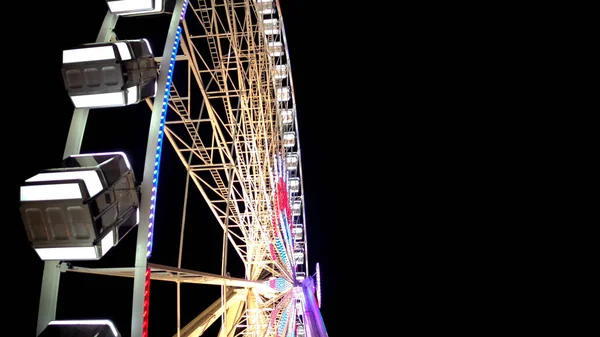 Side view of huge Ferris wheel rotating at amusement park under dark night sky — Stock Photo, Image
