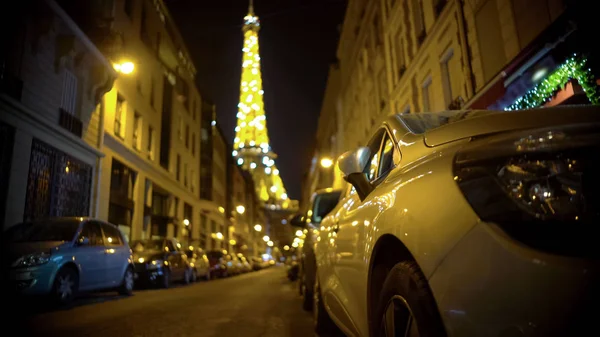 Torre Eiffel desenfocada brillando al final de la calle estrecha, noche en París —  Fotos de Stock