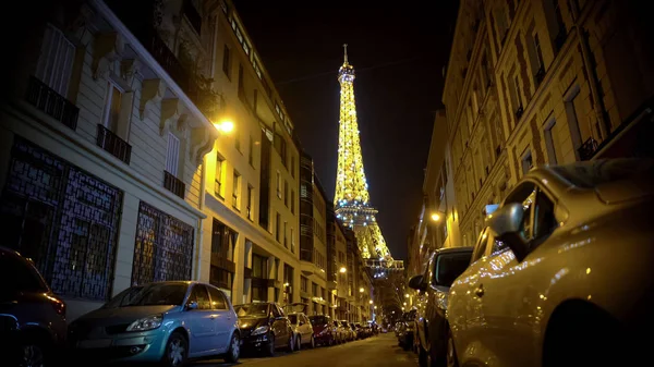 Majestátní osvětlené Eiffelova věž šumivé v noci, výhled z úzké ulice — Stock fotografie