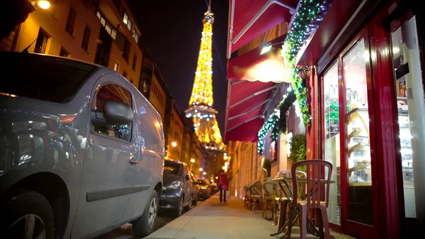 Pequeño café decorado con luces de Navidad, brillante Torre Eiffel en el fondo —  Fotos de Stock