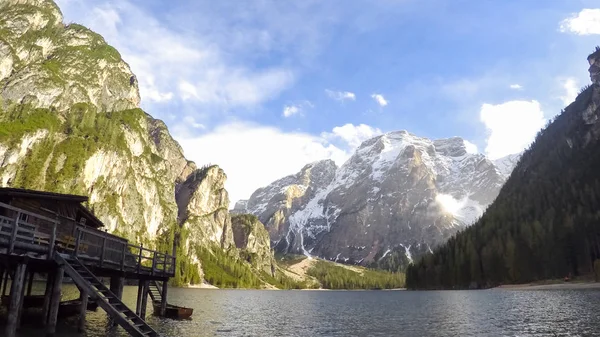 Pragser Wildsee rodeado por altas montanhas rochosas, casa de pescadores nas proximidades — Fotografia de Stock