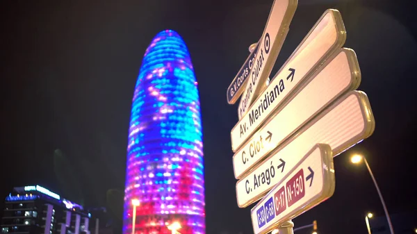 Belysta Torre Agbar skyskrapa, tecken som tyder på gatunamn för turister — Stockfoto