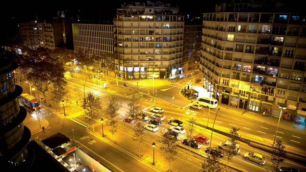 Fényesen kivilágított utcán éjjel, a közlekedési lámpánál, a buszsáv váró autók — Stock Fotó