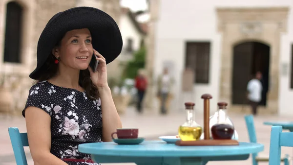 Элегантный женский разговорный телефон с улыбкой на лице, счастливая женщина наслаждается отдыхом — стоковое фото