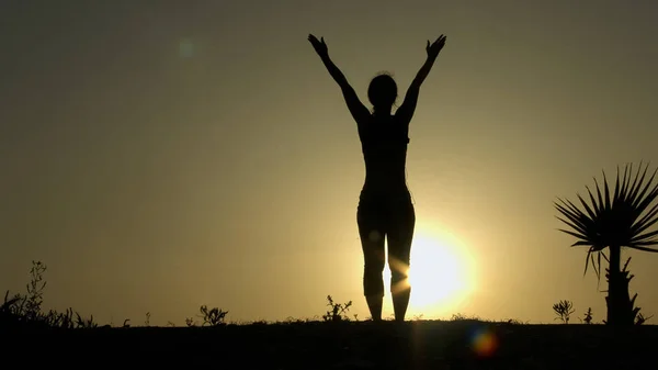 Γυναίκα σιλουέτα την πρακτική της γιόγκα σε ακτίνες του sunrise, ισορροπία του σώματος και του νου — Φωτογραφία Αρχείου